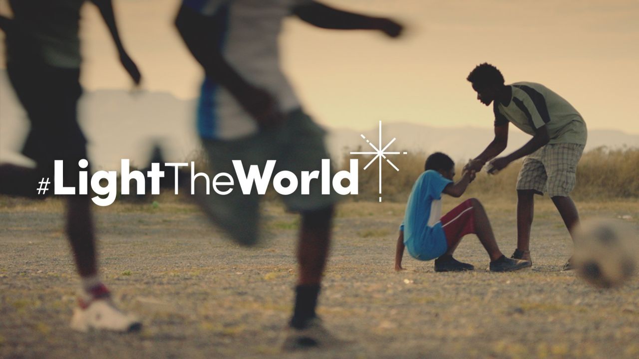 Een jongen helpt een andere jongen opstaan na in een voetbalwedstrijd gevloerd te zijn – uit de video Verlicht de wereld