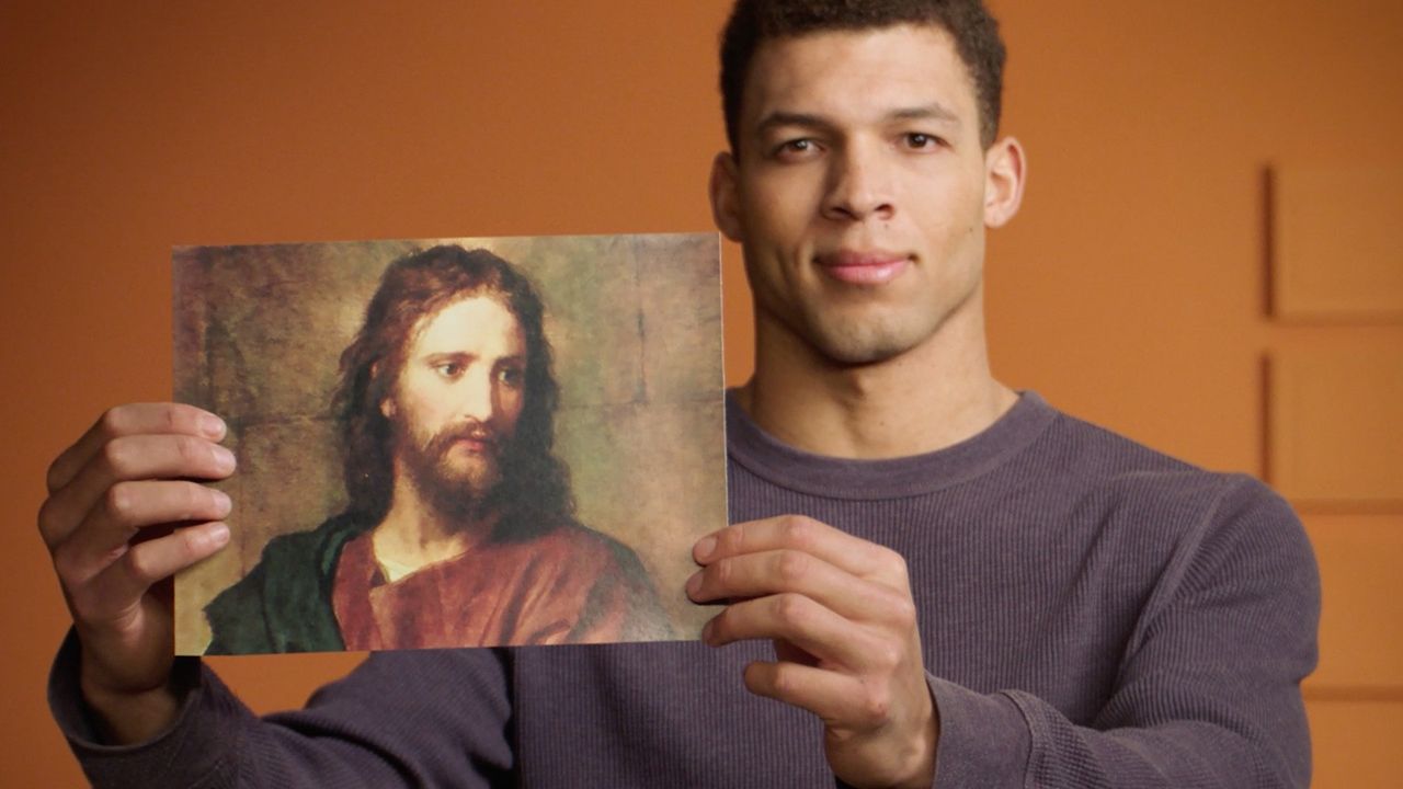Een man houdt een plaat van Jezus Christus omhoog