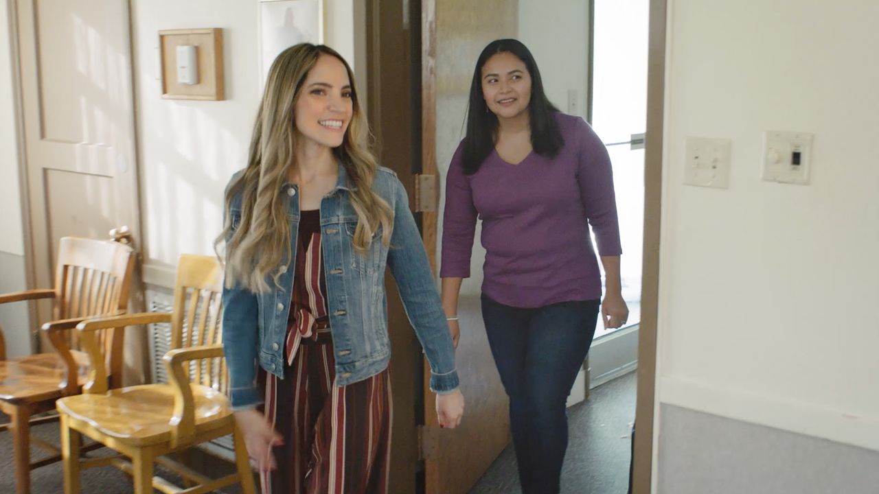 Twee vrouwen lopen door een kerkgebouw en leren over het evangelie van Jezus Christus