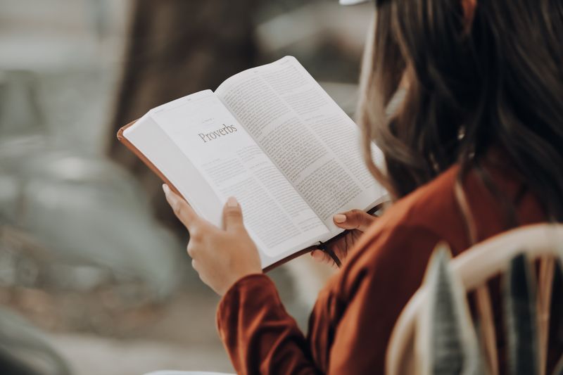 Een vrouw leest het boek Spreuken in de Bijbel