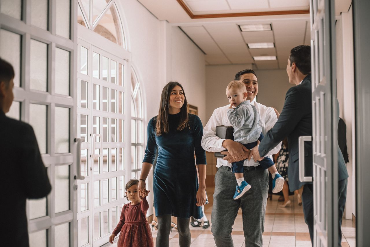 Een jong gezin gaat een kerk binnen om over het evangelie van Jezus Christus te leren